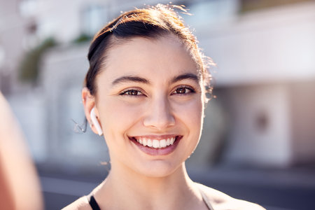 Fitness, exercise and selfie with a woman listening to music for running, workout and cardio training outdoor in a city. Portrait, face and smile of female happy for social media inspirationの写真素材
