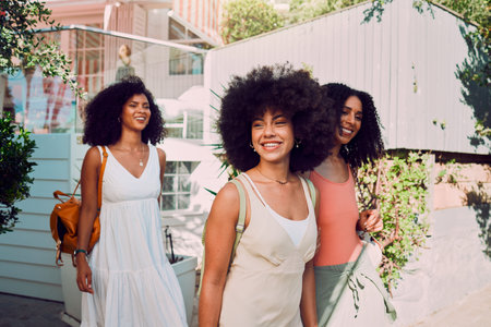 Travel, friends and black woman in summer walking by the countryside or neighborhood with outdoor fashion, wellness and youth lifestyle. Happy gen z, women or group of people with adventure and smileの写真素材