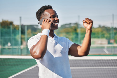 Black man, tennis and phone call in celebration for win, victory or achievement for winning tournament. Happy African American tennis player male winner with smile celebrating in phone conversationの写真素材