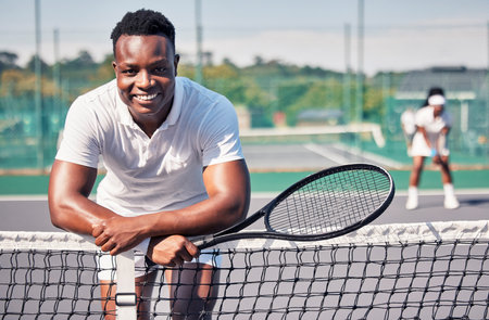 Tennis, fitness portrait or black man with smile for training, motivation or sport workout in tennis court. Athlete, happy or tennis player for wellness, exercise or health outdoors leaning on netの写真素材