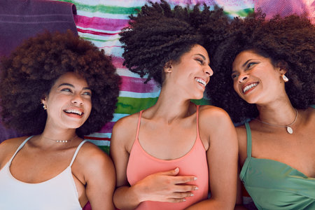 African women, happy and friends on floor for support, love and care or bonding together at beach. Black girls, smile and friendship happiness, laughing with afro and fun on summer holidayの写真素材