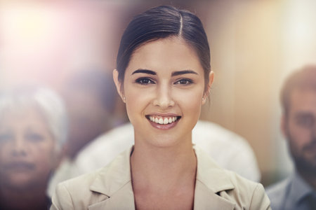 She brings her A-game to work every day. Portrait of a young businesswoman standing in front of her colleagues.の写真素材