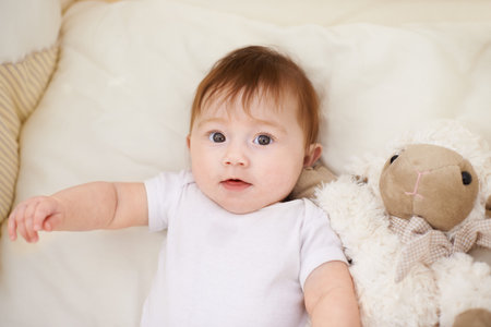 Could someone pick me up, please. High angle shot of an adorable baby in a cot.