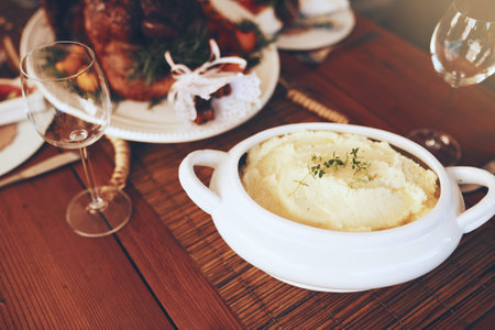 Food, mashed potatoes and dining table for thanksgiving or Christmas holiday celebration with home cooking for lunch or dinner nutrition. Puree potato, roasted chicken and wine glass backgroundの写真素材