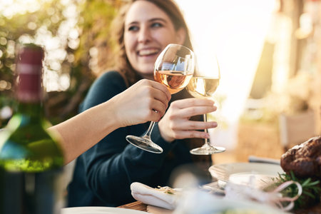 Wine, cheers and friends with a wine glass to toast at a party, event or celebration in nature. Happiness, holiday and people with a glass of a luxury alcohol drink or champagne to celebrate togetherの写真素材