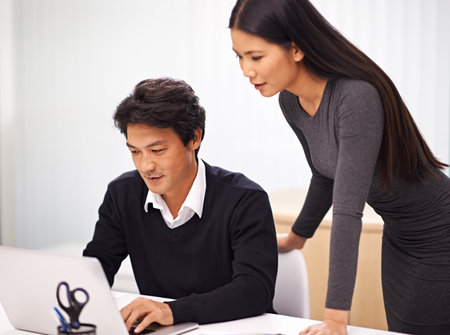 Theyre an experienced team. two business colleagues working together at a laptop in the office.の写真素材
