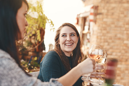 Wine, women or friends toast in celebration of friendship loyalty, trust or support at an outdoor social event. Smile, cheers and happy people drinking luxury champagne enjoy relaxing at a restaurantの写真素材