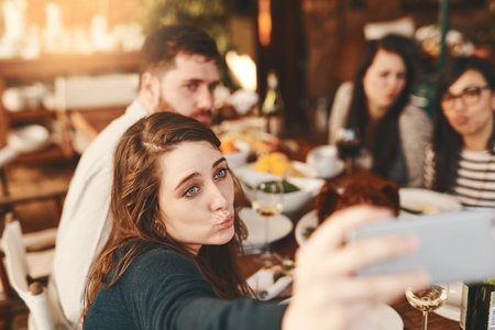 Selfie, restaurant and dinner of people at party for celebration, holiday or thanksgiving and friends. Fine dining, food and influencer friends in smartphone photography for social event lifestyleの写真素材