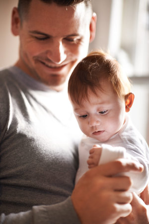 My finger may be small but I can still wrap daddy around it. a young father holding his adorable...