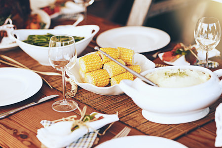 Table, food and vegetables for dinner and party to celebrate Christmas, Thanksgiving or anniversary. Feast, holiday and celebration with table setting, meal for dinner party and vegetable dish.の写真素材