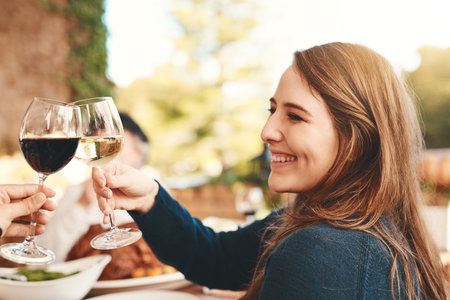 Wine toast, glasses and celebration dinner party with a woman happy about holiday event. Food, happiness and christmas lunch of female cheers with alcohol drink to celebrate gratitude outdoorの写真素材