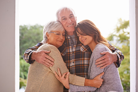My two favourite girls. A cropped portrait of a happy senior man standing at home with his wife and daughter.の写真素材