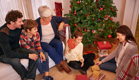 Christmas, family and open present in lounge, happy and smile together for festive season. Xmas,...