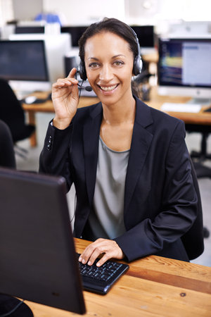 She handles her clients professionally. an attractive female call center representative wearing a...