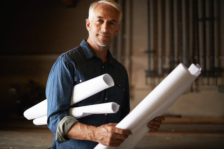 Time to put this plan into action. Portrait of a handsome senior architect holding his plans.
