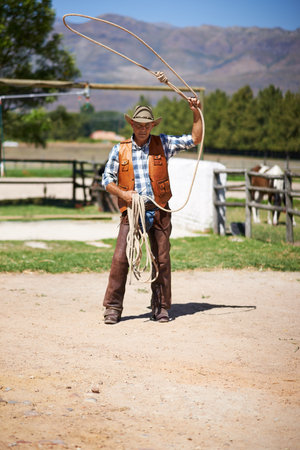 Time to lasso an outlaw. a man with a lasso on the farm.の写真素材