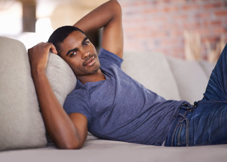 Enjoying his downtime. a handsome young man relaxing at home.の写真素材
