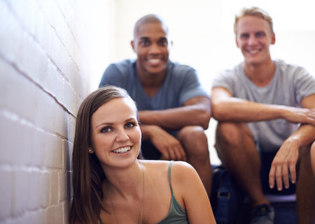 Relaxing before the final exam. university students sitting in a hallway.の写真素材