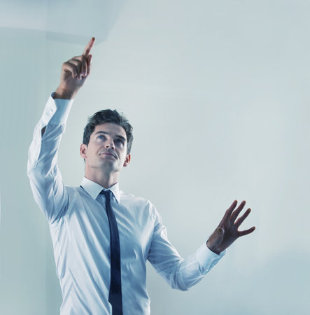 The future is now - Touchscreen technology. a young businessman using an unseen digital interface.の写真素材