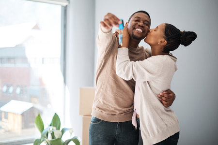Real estate, home and couple with keys for moving in, dream home and property, happy and kiss mockup. Portrait, man and woman hug in celebration of house, sale and success, mortgage and investmentの写真素材