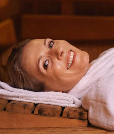 Feeling relaxed and laid back. a mature woman in a sauna.の写真素材