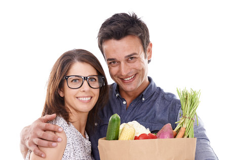 Only the best for us. Studio portrait of a couple with groceries isolated on white.の写真素材