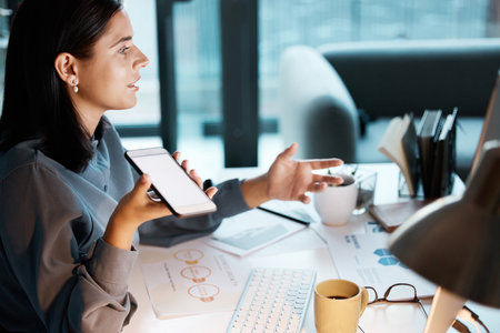 Communication, office and business woman on a phone call for discussion, virtual meeting and talking to client. Startup, mockup screen and girl working, speaking and in conversation on smartphoneの写真素材