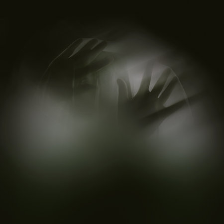 Fingers of icy fear. A ghostly apparition of a woman isolated on a black background.の写真素材