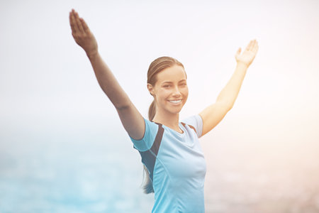Fresh air never felt so good. a young woman training outdoors with her arms outstretched.の写真素材