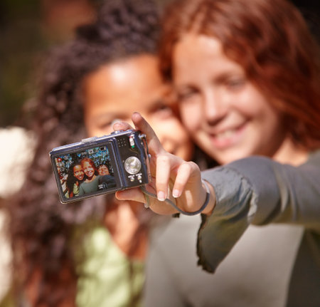 Capturing everlasting memories. a two young girls taking a self-portrait outdoors.の写真素材