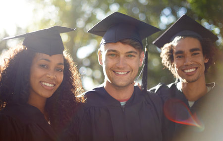 Graduation day. Portrait of three happy students on graduation day.の写真素材