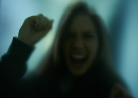 Dont leave me like this. woman behind a glass wall during quarantine.の写真素材