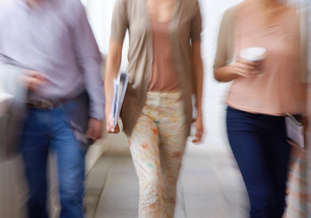 The business world is always moving. three blurred office workers.の写真素材