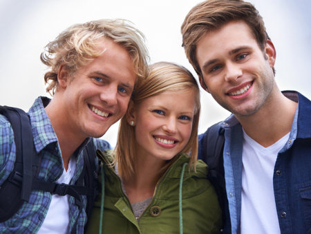 Backpacking buddies. A group of happy young people standing together in the outdoors.の写真素材