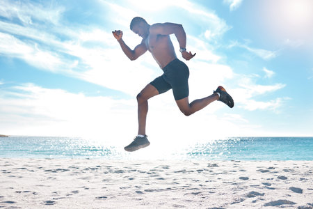 Fitness, runner and jump of black man at beach for cardio workout, training and wellness body....