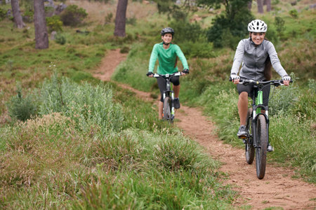 Enjoying a leisurely ride. Two young cyclists enjoying their ride along a trail.