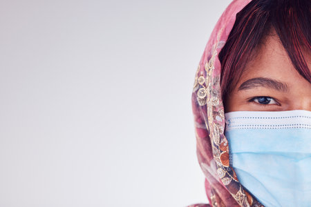 Covid face mask, muslim woman and mockup, healthcare risk or safety compliance on studio background space. Portrait islamic lady in hijab from Malaysia, corona virus and medical wellness with mock upの写真素材