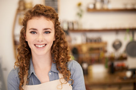 Expert Barista - put in your requests. Closeup portrait of an attractive young barista standing in a cafe.の写真素材