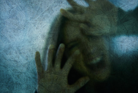 Trapped and desperate. woman behind a glass wall during quarantine.