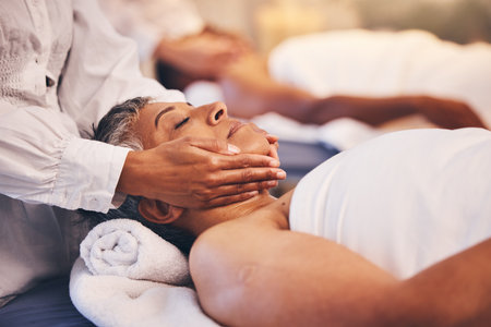 Spa, facial and massage of senior woman for peace, relaxation and wellness procedure lifestyle. Health, physical therapy and masseuse at luxury resort massaging client on salon treatment bed.の写真素材