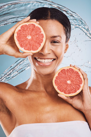Beauty, water splash and grapefruit for skincare, black woman in portrait, natural vegan and healthy cosmetics for detox and skin. Fruit, vitamin c and water with splash for hydration and cosmetic.の写真素材