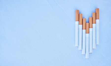 Cigarettes in a studio against a blue background mockup for cancer, toxic and addiction awareness. Cigarette, tobacco business and industry advertising for smoke, marketing and smoking marketの写真素材