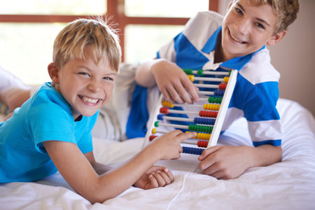 Old-school math. Portrait of two young siblings playing with an abacus.