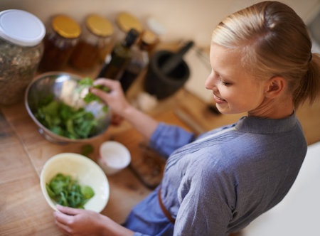 Made with love and care. High angle shot of a woman preparing a salad in a kitchen.の写真素材
