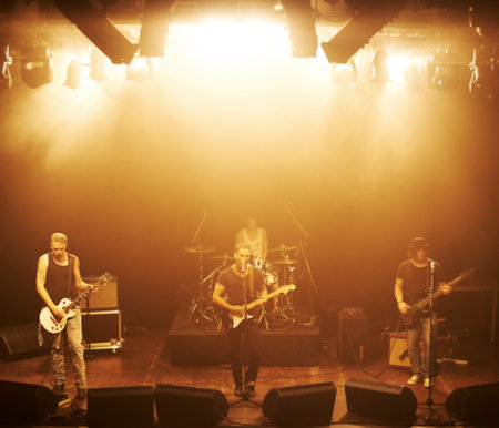 a four-piece band playing a live concert. This concert was created for the sole purpose of this photo shoot, featuring 300 models and 3 live bands. All people in this shoot are model released.の写真素材