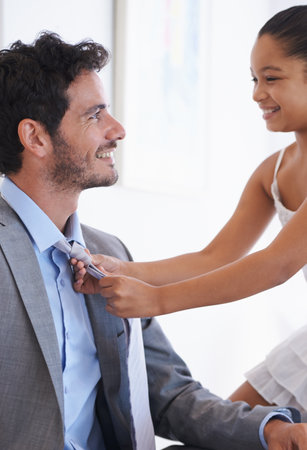 She can teach him a thing or two about neckties. a father and young daughter sharing a moment together in the morning.の写真素材
