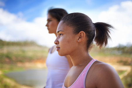 Focussed on the run. Two young women jogging outside - profile.の写真素材