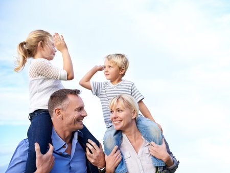 High five to family time. Cropped view of two parents carrying their children on their shoulders...