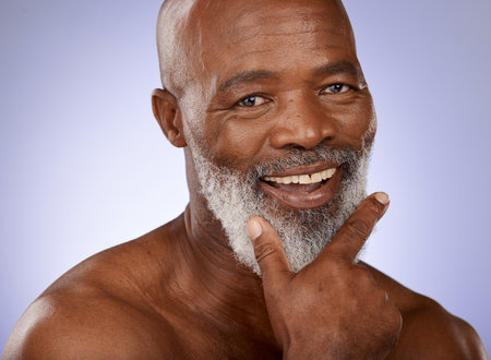 Portrait, skincare and black man with beard, wellness and natural beauty on studio background. Cosmetics, happy senior gentleman and African American male with organic facial, smooth and clear skin.の写真素材