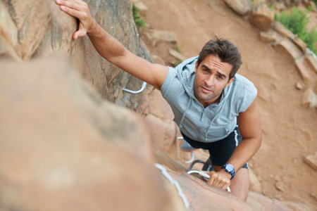 Keeping the blood and adrenaline flowing. Young mountain climber scaling a cliff - high angle view.